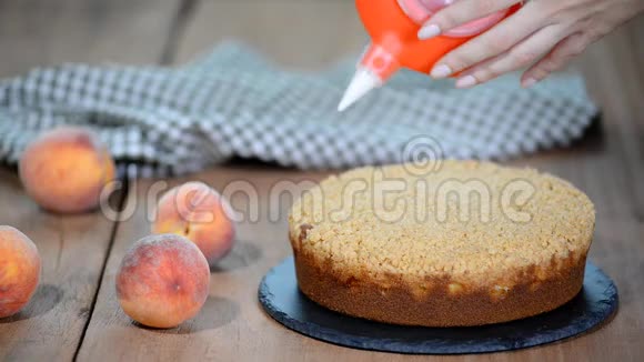 用一个管道袋用糖霜装饰蛋糕夏天的桃子派和焦糖饼视频的预览图