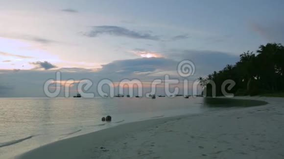 海滩上美丽的日落很漂亮的背景碧水白沙上淡蓝天白云背景视频的预览图