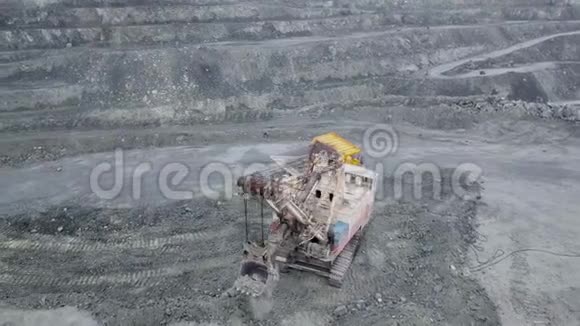 露天挖掘机顶视图挖掘机落在室外采石场翻斗车内的碎石中提取矿物视频的预览图