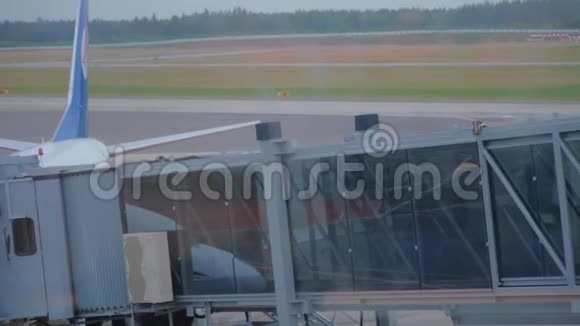 两名乘客通过空中天桥登上飞机的剪影视频的预览图