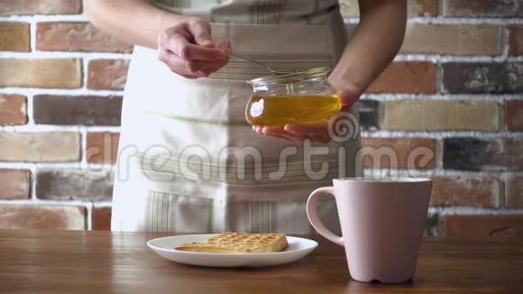 女人在华夫饼上倒入蜂蜜视频的预览图