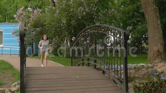 一个年轻漂亮的女孩跑过爱情的桥梁和男朋友夫妻的约会视频的预览图