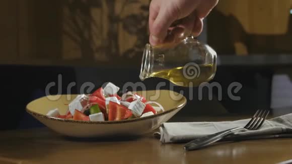 厨师将传统的希腊色拉配以玻璃壶中的橄榄油视频的预览图