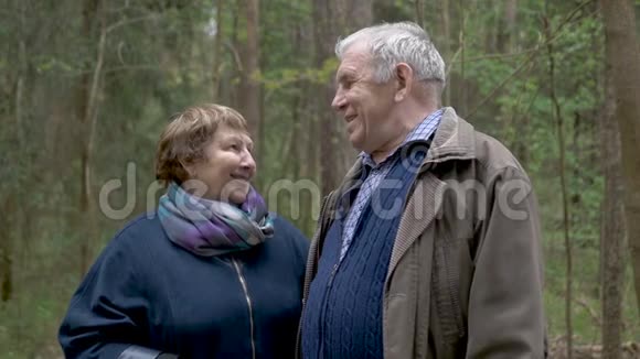 一对漂亮的老夫妇正在公园里散步轻轻地抓住互相看着笑着说话良好关系视频的预览图