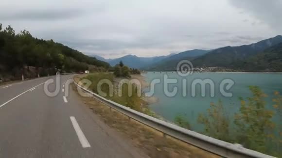 骑摩托车的人沿着法国山湖附近的骑车POV视频的预览图