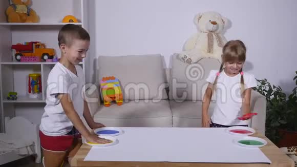 一个女孩和一个男孩在纸上留下手印时间流逝视频的预览图