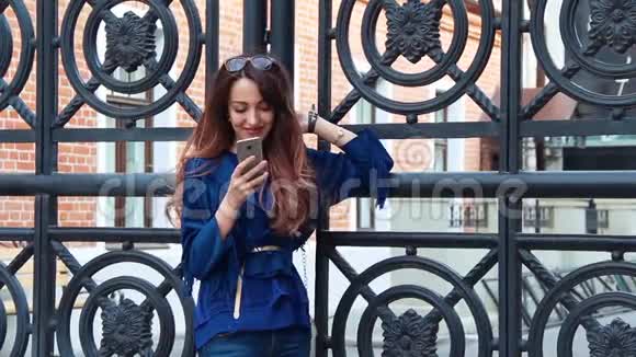快乐的年轻女性在街上使用手机写短信和查看电子邮件视频的预览图