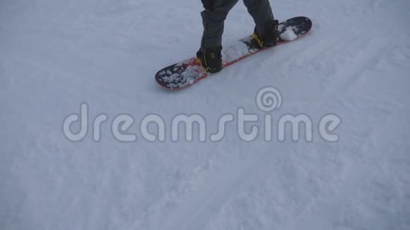 在山上的雪坡上滑动着无法辨认的雪板脚年轻人在滑雪场的山上学习骑马视频的预览图