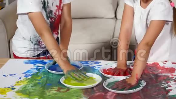 女孩和男孩把衬衫涂在油漆上视频的预览图