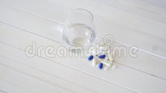 白色木桌上的水晶水和一套药丸视频的预览图
