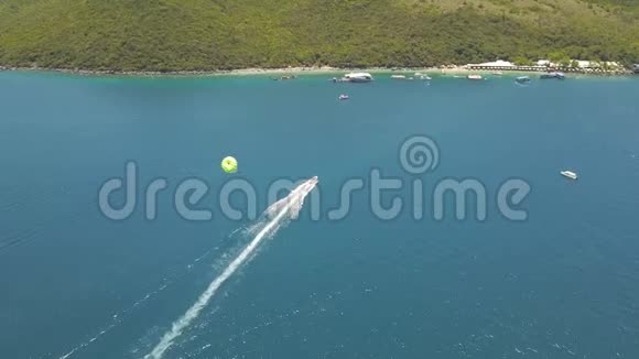 在蓝海湾无人机视野中寄生鸟瞰帆船与滑翔伞在绿松石海美丽的风景视频的预览图