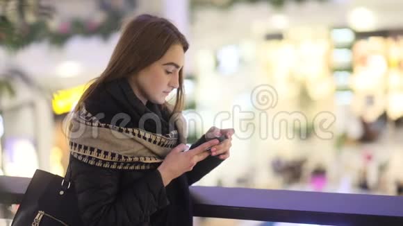漂亮的微笑模特学生女孩在贸易中心敲电话稳定的凸轮慢镜头视频的预览图