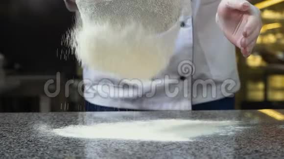 厨师的手把面粉扔进筛子里视频的预览图