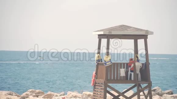 救生员塔上一个阳光明媚的夏日背景是蓝天和大海视频的预览图