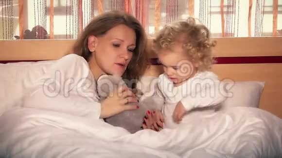 可爱的小女孩和她美丽的年轻妈妈为玩具熊唱摇篮曲视频的预览图