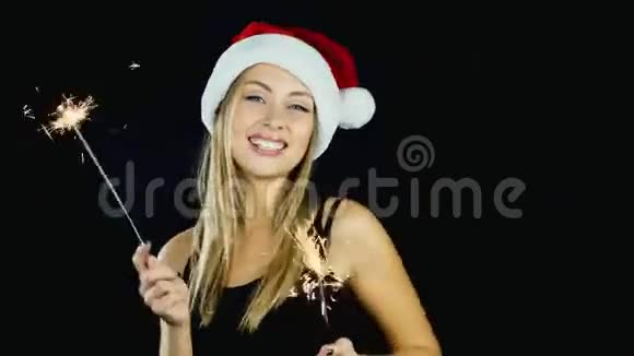 一个迷人的女人两盏孟加拉灯在黑色背景上跳舞概念庆祝圣诞节和视频的预览图