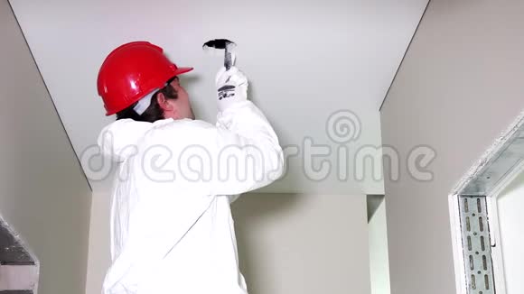 年轻男电工用手锯切割天花板上的洞视频的预览图