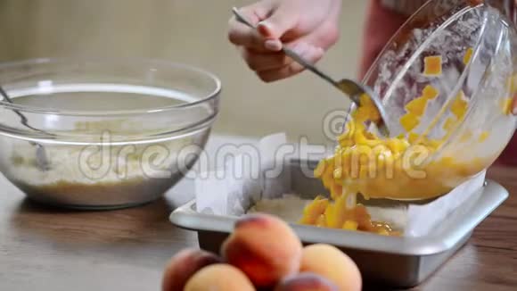 厨房里的女人准备一个带桃子的蛋糕视频的预览图
