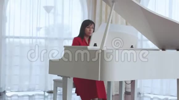美丽的女人弹着白色的钢琴视频的预览图