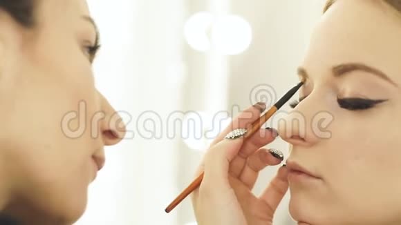 女人化妆师用化妆品刷化妆眼睛和眉毛作为美容模特快去化妆师那里视频的预览图