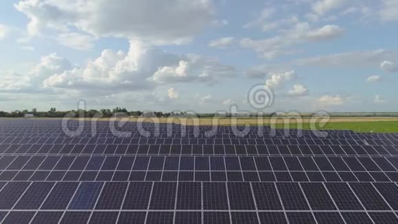 飞过一片太阳能电池板环绕着绿色的田野可再生能源太阳能电池板视频的预览图