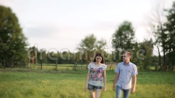 可爱的情侣在田野里散步视频的预览图