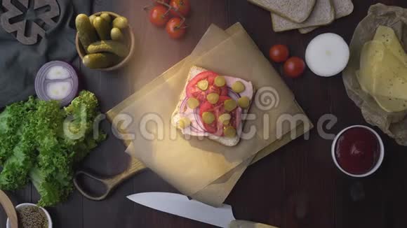 将火腿腌菜和蔬菜切成薄片的三明治放在木板上放在光线下做成视频的预览图