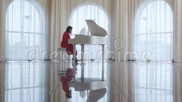 美丽的女人弹着白色的钢琴视频的预览图