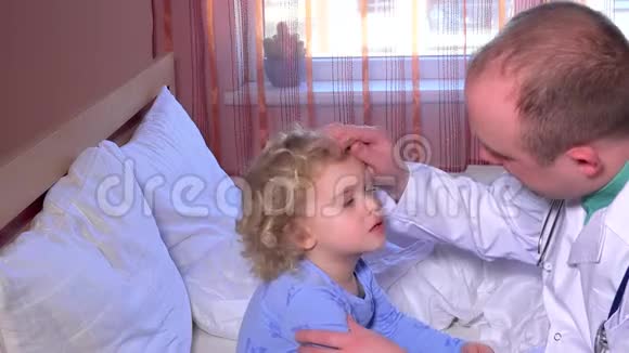 专业男医生在床上检查他的小病人的喉咙视频的预览图