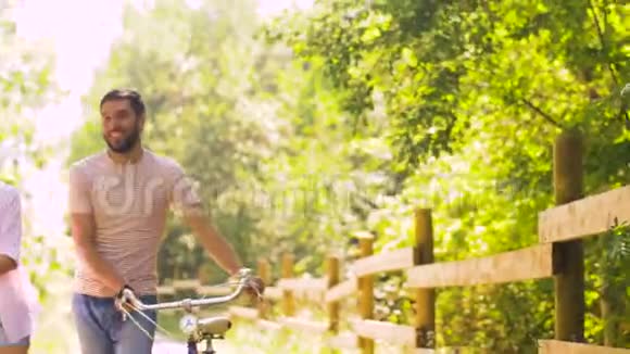 一对骑着自行车漫步在夏日公园视频的预览图