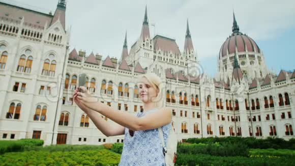 环游欧洲一位游客在布达佩斯匈牙利议会的背景下自拍视频的预览图