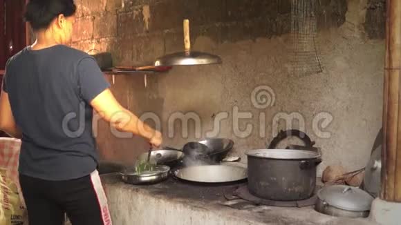 女人在肮脏的厨房里用老式的方式做饭视频的预览图