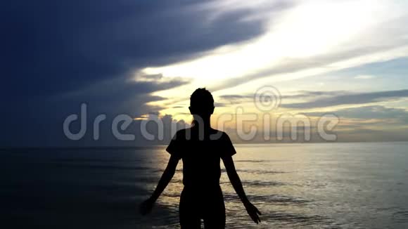 剪影女在日出时在海上练习瑜伽视频的预览图