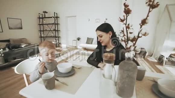 快乐的年轻家庭在家度假时在厨房吃早餐视频的预览图