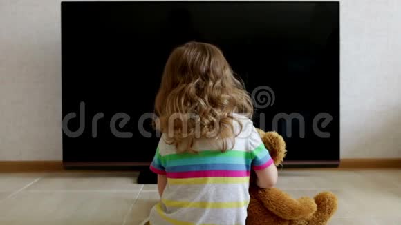 概念描述小女孩正坐在电视机的黑屏上视频的预览图