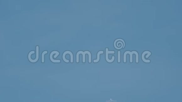 飞机在飞行中在蓝天上形成一条白色的条纹称为对迹凝结痕迹或蒸汽痕迹视频的预览图