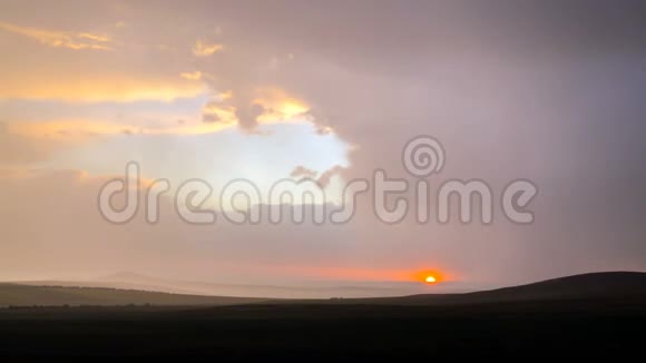 4K时程在草原上多云的天空背景下的雷雨中日落视频的预览图