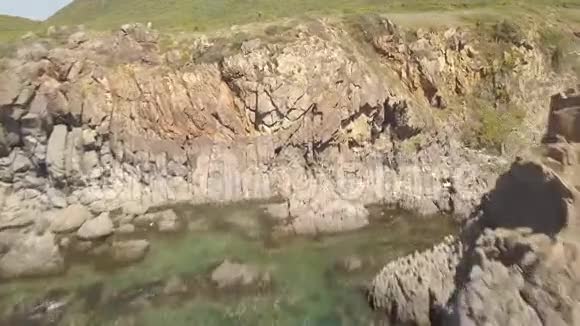 岩石悬崖和海水在海湾空中景观从上面空中射击飞行无人机山崖和蓝海视频的预览图