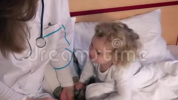 沮丧的小女孩和医生用温度计测量她的体温视频的预览图