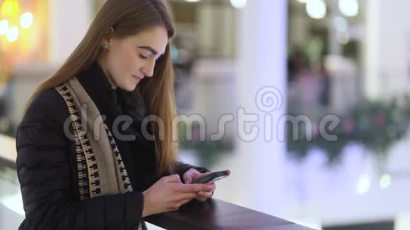 美丽的东欧女孩棕色头发试图与她的朋友在巨大而美丽的购物中心聊天视频的预览图
