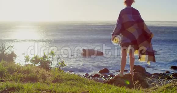 阳光明媚的4k天气站在海边的女人视频的预览图
