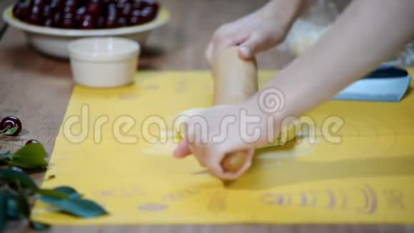 女人的手把面团放在厨房的桌子上用浆果做一个馅饼视频的预览图