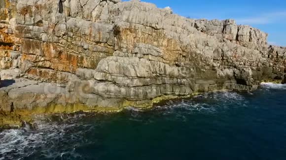 高空俯视图海浪冲刷岩石海岸线视频的预览图