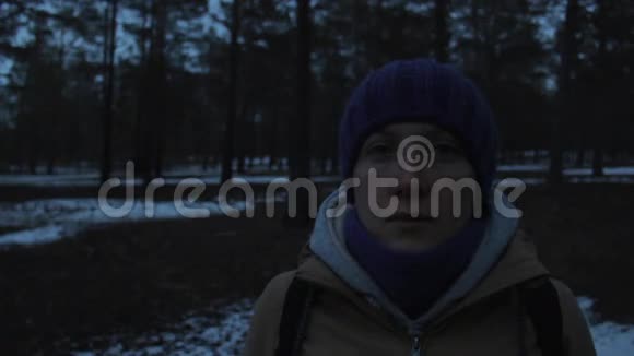 一个女孩在寒冷黑暗的冬林中的肖像视频的预览图