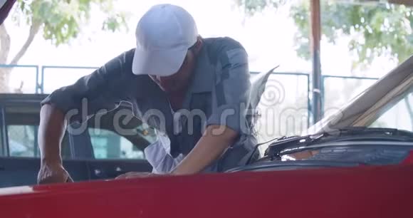 专业的男工修理车库里的汽车汽车服务概念视频的预览图