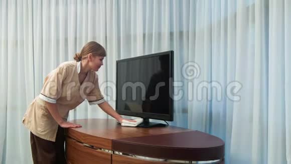 积极微笑的女仆擦电视机视频的预览图