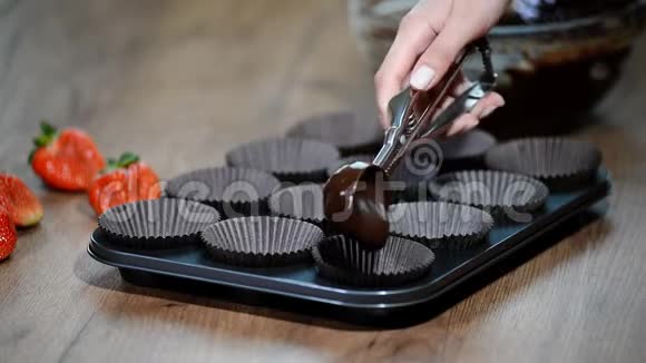 将蛋糕拌入锅中做巧克力松饼的女人视频的预览图