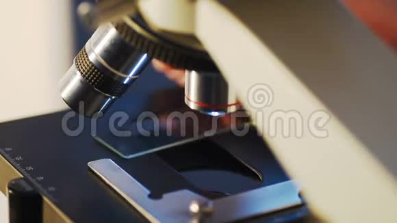 用显微镜特写科学家的手检查样品视频的预览图