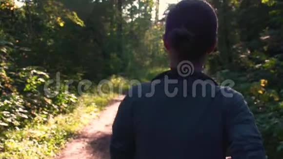 日落时穿过森林的年轻女子嘲笑大自然慢速运动120fps视频的预览图