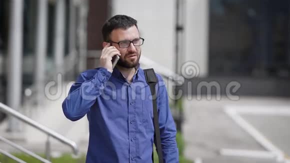 一个上班族也许是一个经理白天在他工作的附近的街道上用手机说话他在视频的预览图